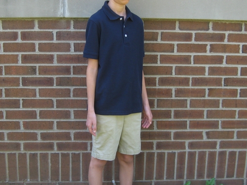 Boy wearing French Toast pique polo and flat front stretch shorts