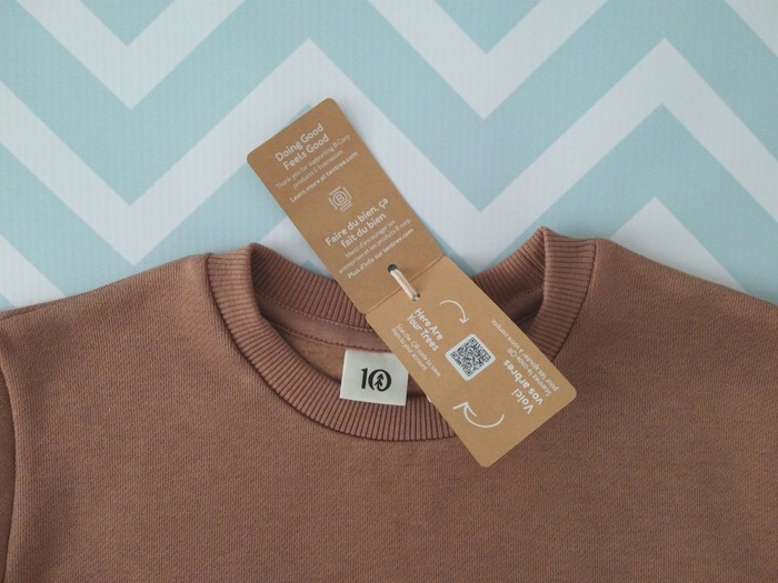 close-up of tentree toddler sweatshirt with product information tag showing tree planting tracking